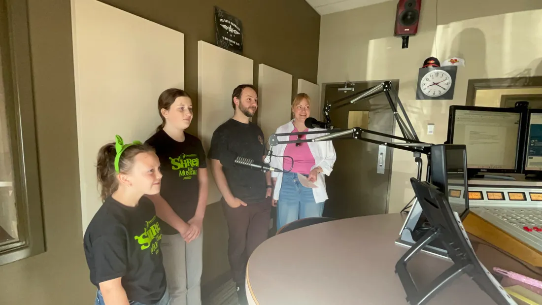 Students singing together during a stage production.
